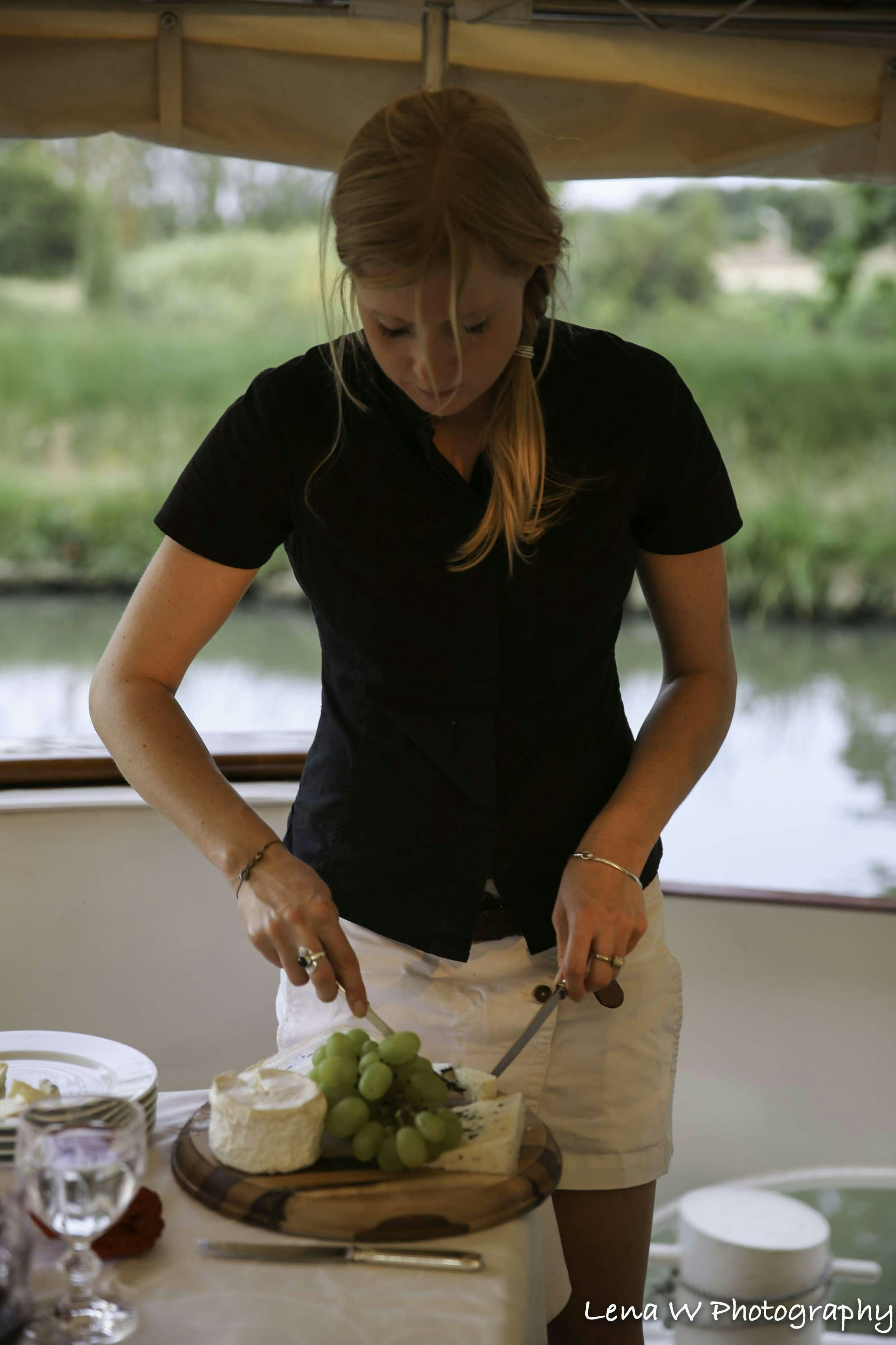 a woman cutting a fruit aboard ROI SOLEIL Yacht for Charter
