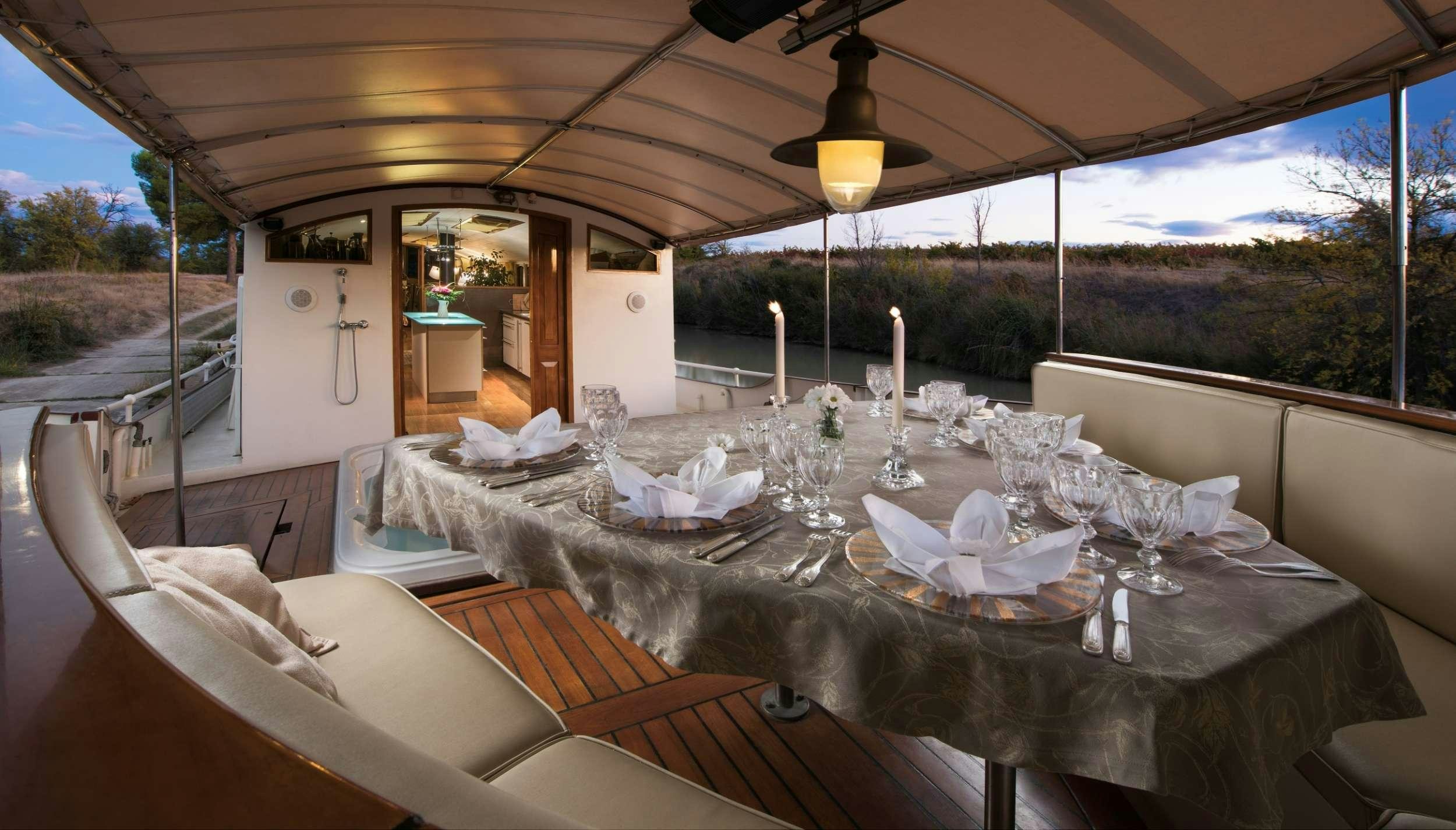 a table with white cloths and candles on it aboard ROI SOLEIL Yacht for Charter