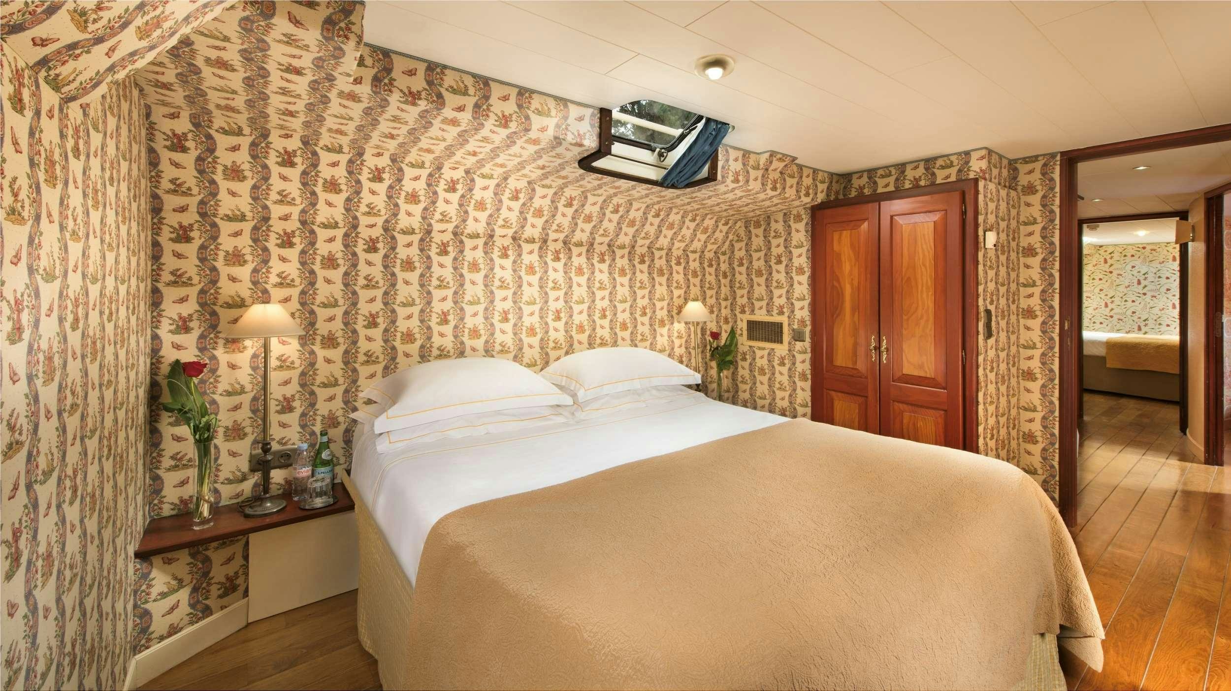 a bedroom with a bed and a television on the wall aboard ROI SOLEIL Yacht for Charter