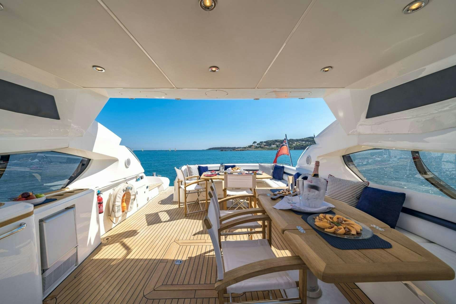 a boat with a table and chairs aboard REHAB Yacht for Charter