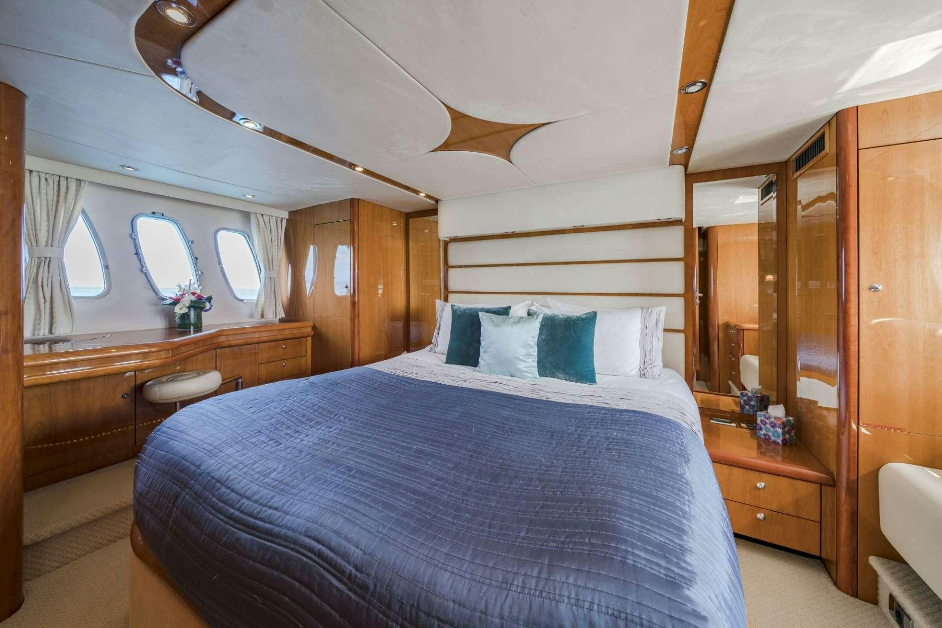 a bed with a blue comforter aboard REHAB Yacht for Charter