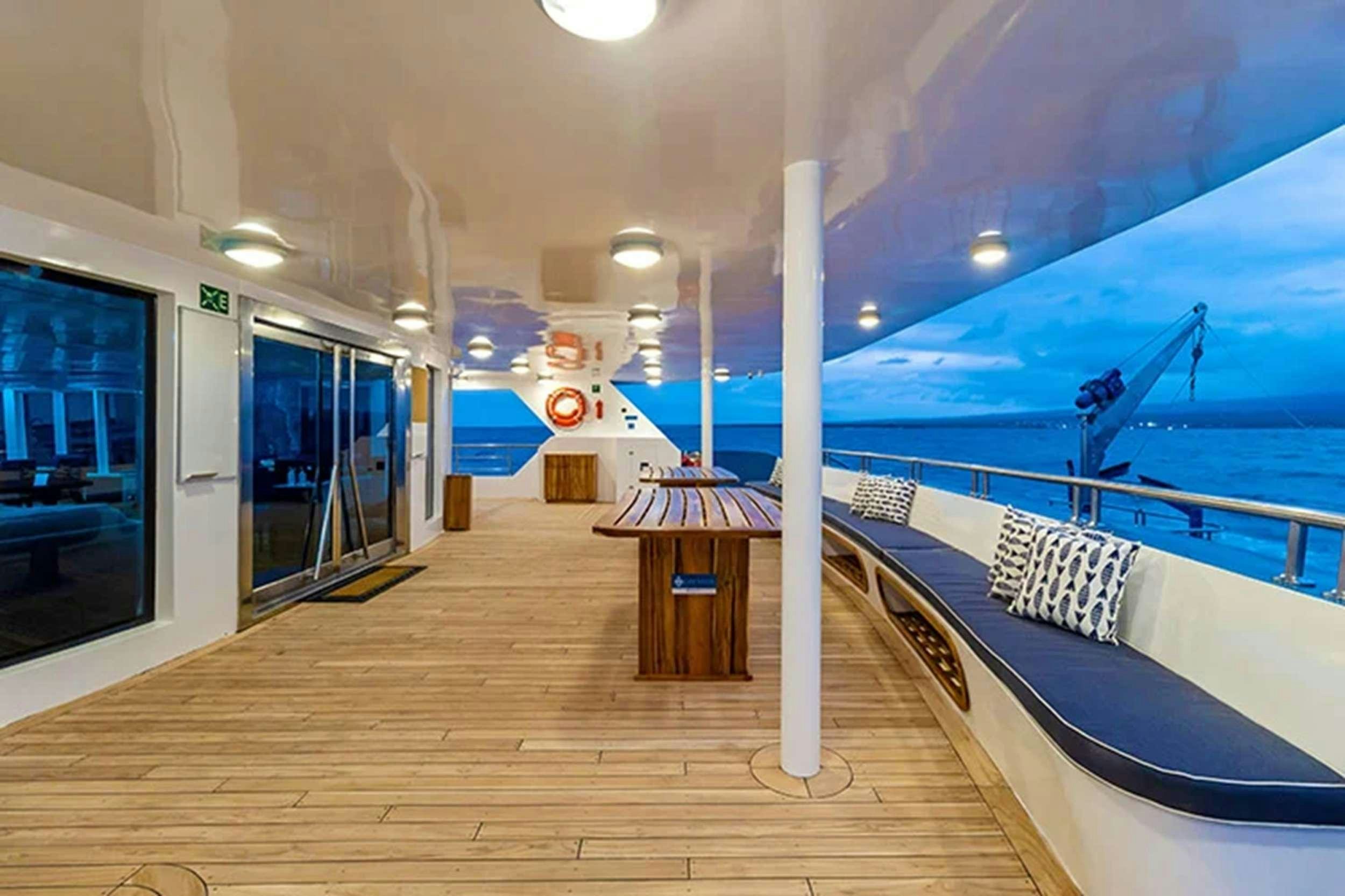 a deck with a railing and a plane on the side aboard CORMORANT II Yacht for Charter