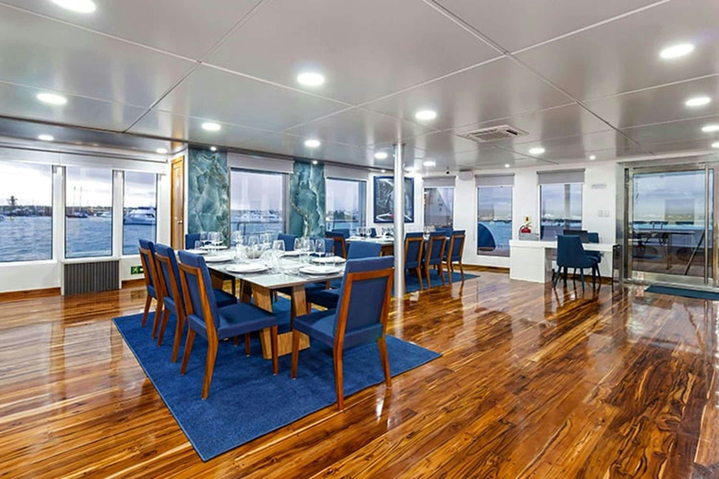 a large room with tables and chairs aboard CORMORANT II Yacht for Charter