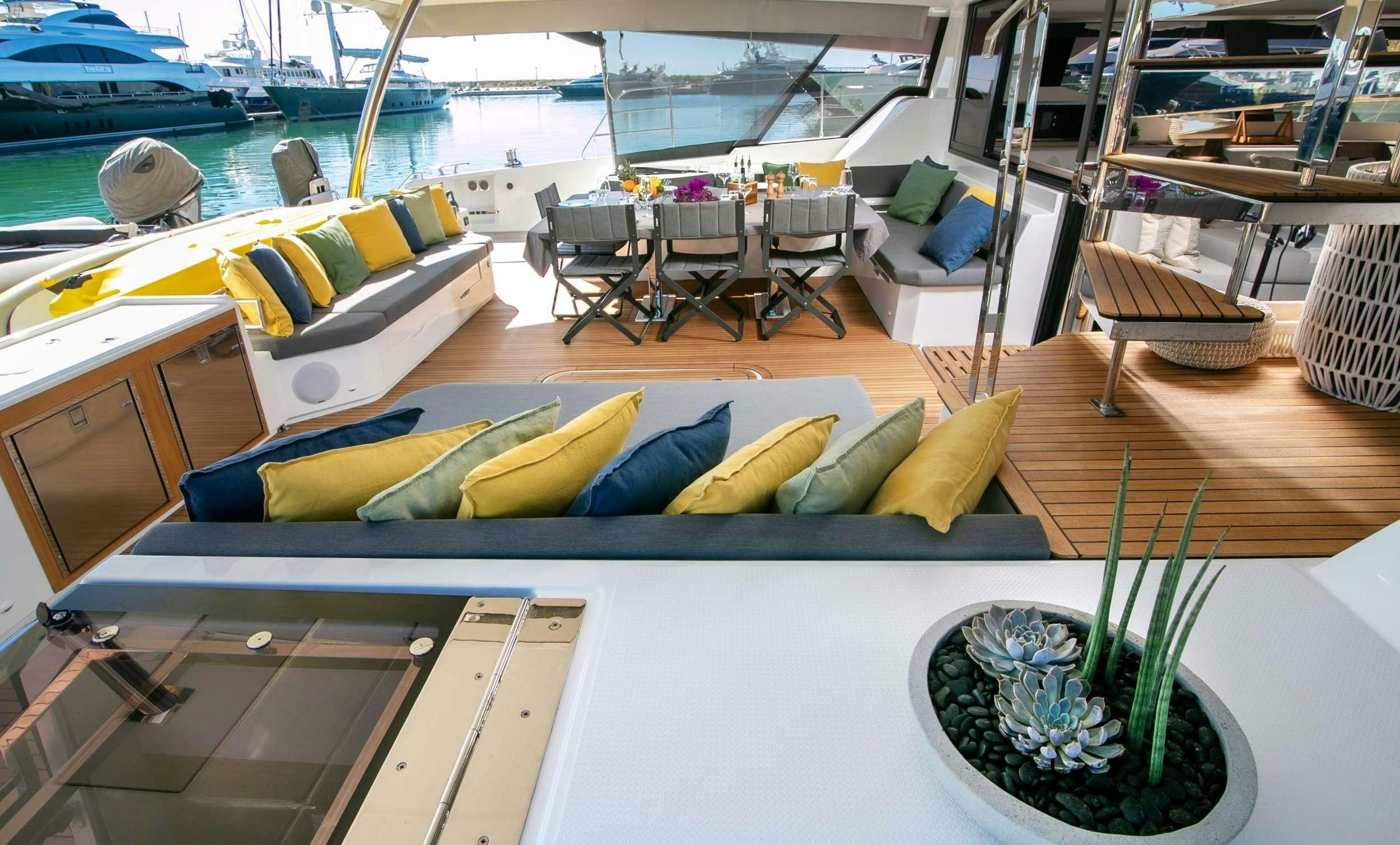 a table with chairs and a plant on it aboard ALOIA  Yacht for Charter