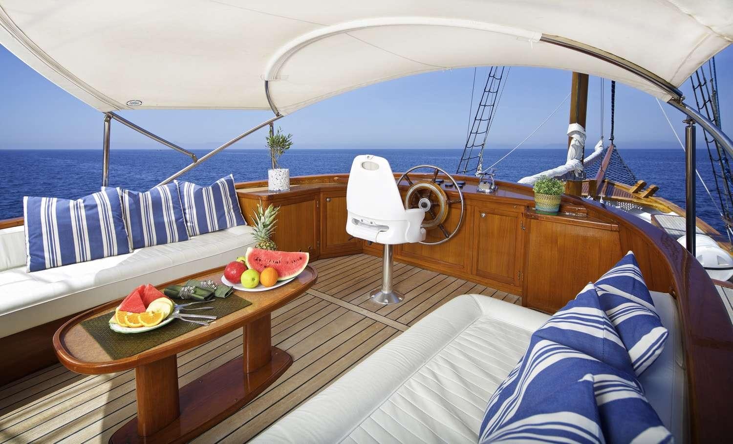 a boat with a table and a bed with fruit on it aboard HERMINA Yacht for Charter