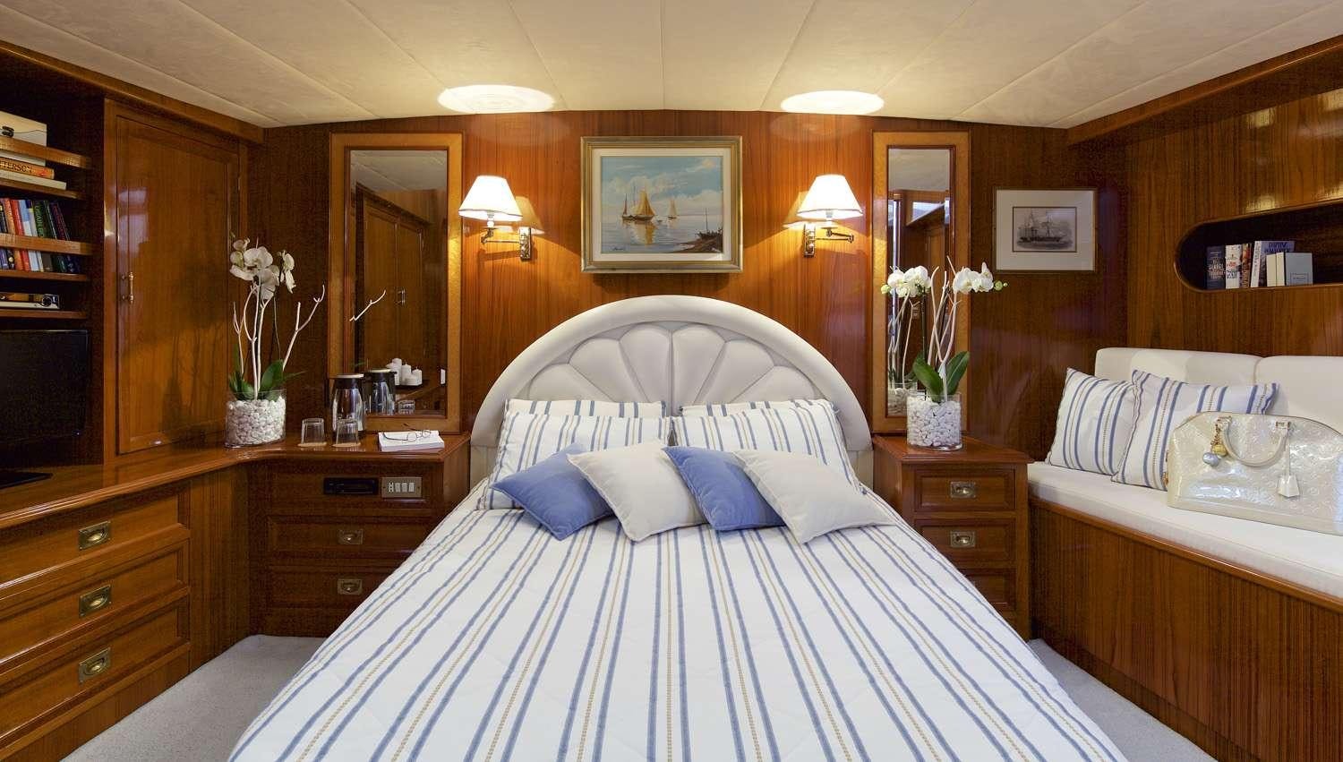 a bedroom with a bed and a mirror aboard HERMINA Yacht for Charter