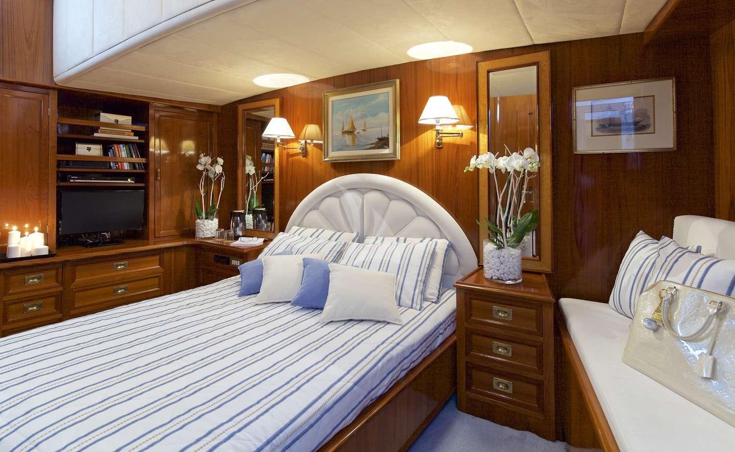 a bedroom with a bed and a television aboard HERMINA Yacht for Charter