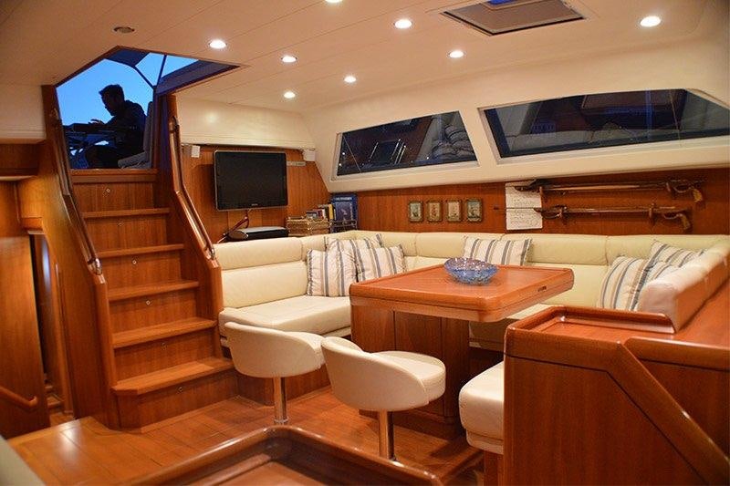 a living room with a tv and a table aboard TERRA DI MEZZO 3 Yacht for Charter