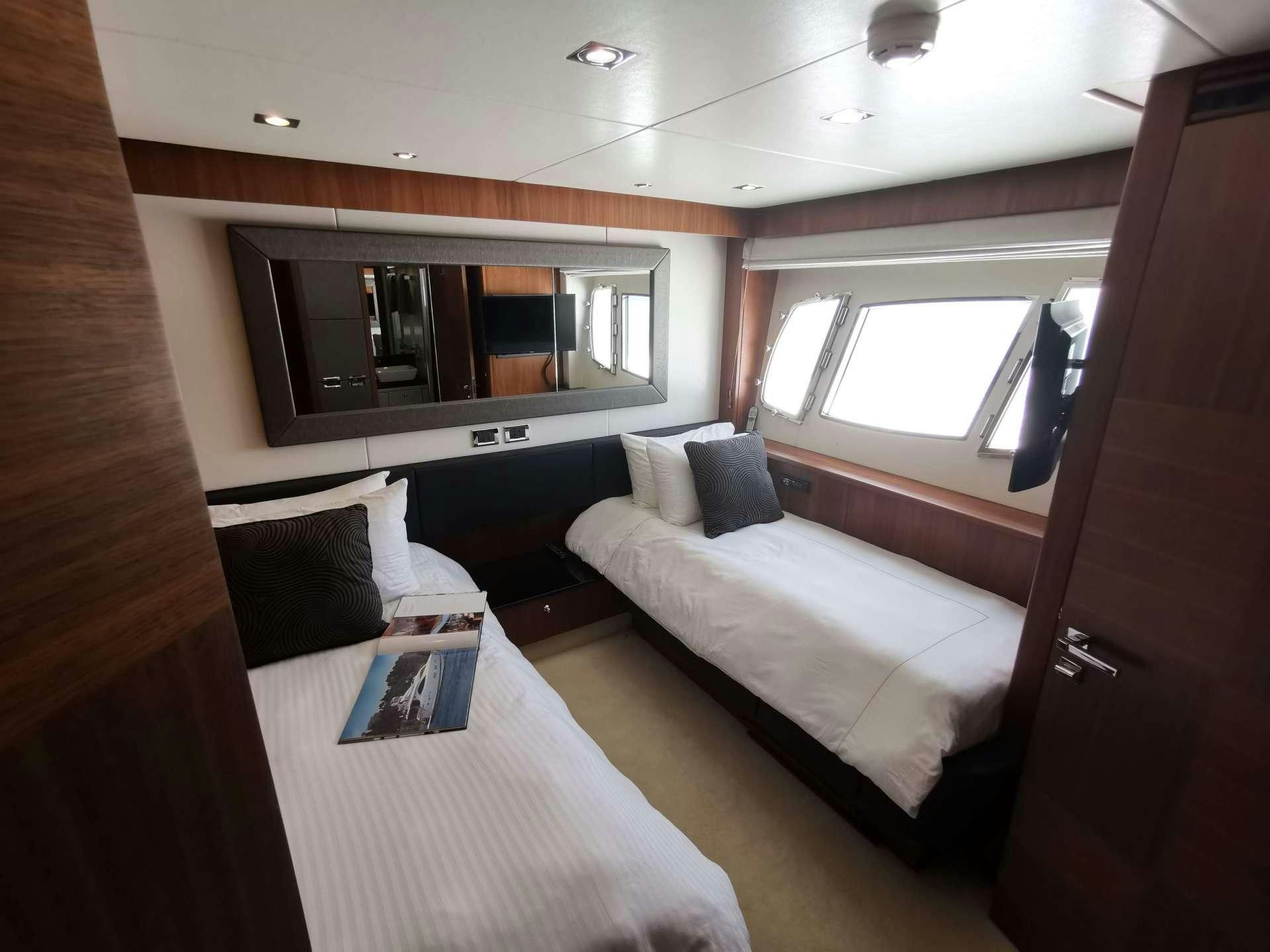 a room with a bed and a television aboard SYDNEY Yacht for Charter