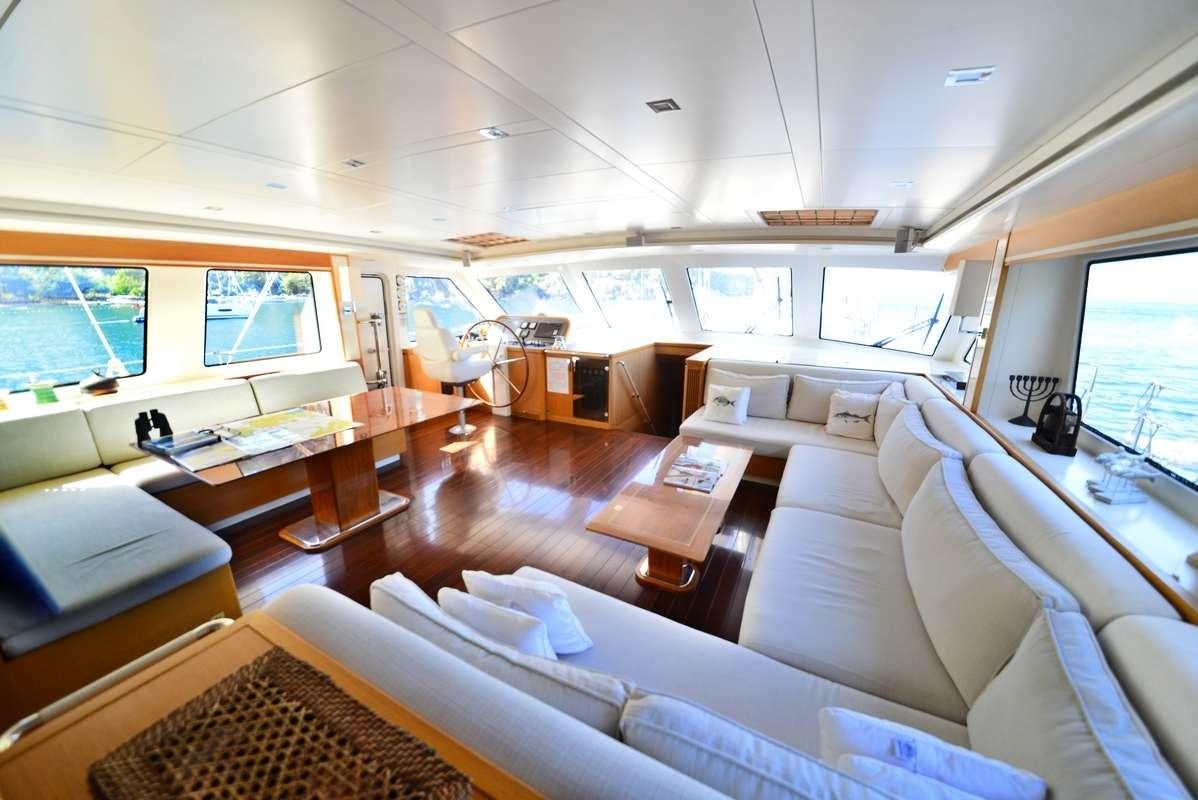 a room with a large window and a table with chairs and a television aboard ZELDA Yacht for Charter