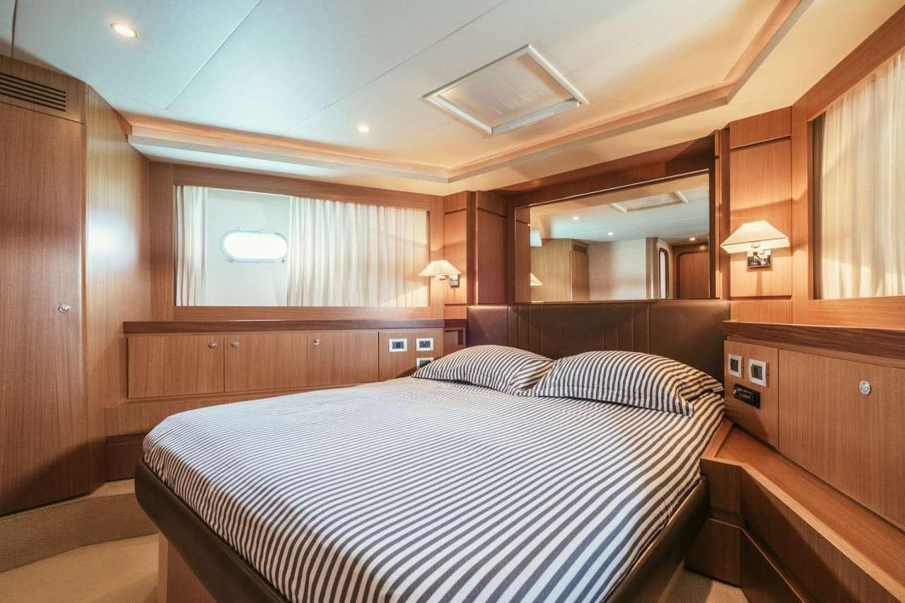 a room with a bed and a mirror aboard TO ESCAPE Yacht for Charter