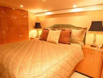 a bed with a lamp on the side aboard PRIORITY Yacht for Charter