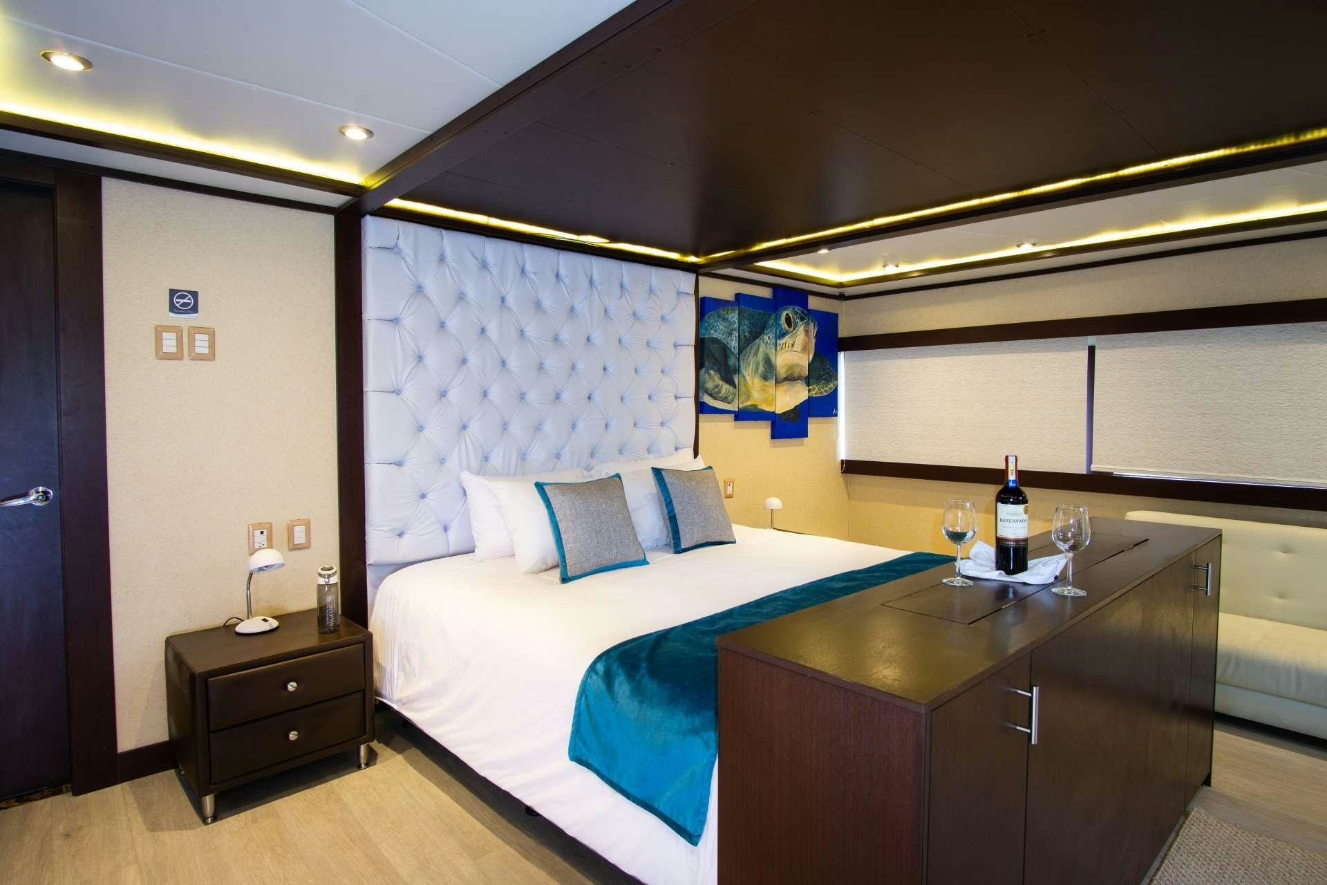 a bed with a blue sheet aboard GRAND MAJESTIC Yacht for Charter