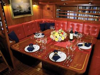 a table set with plates and glasses aboard MELINKA Yacht for Charter