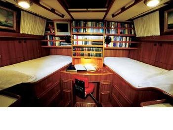 a room with a desk and a bed aboard MELINKA Yacht for Charter