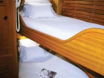 a bed with white sheets aboard MELINKA Yacht for Charter