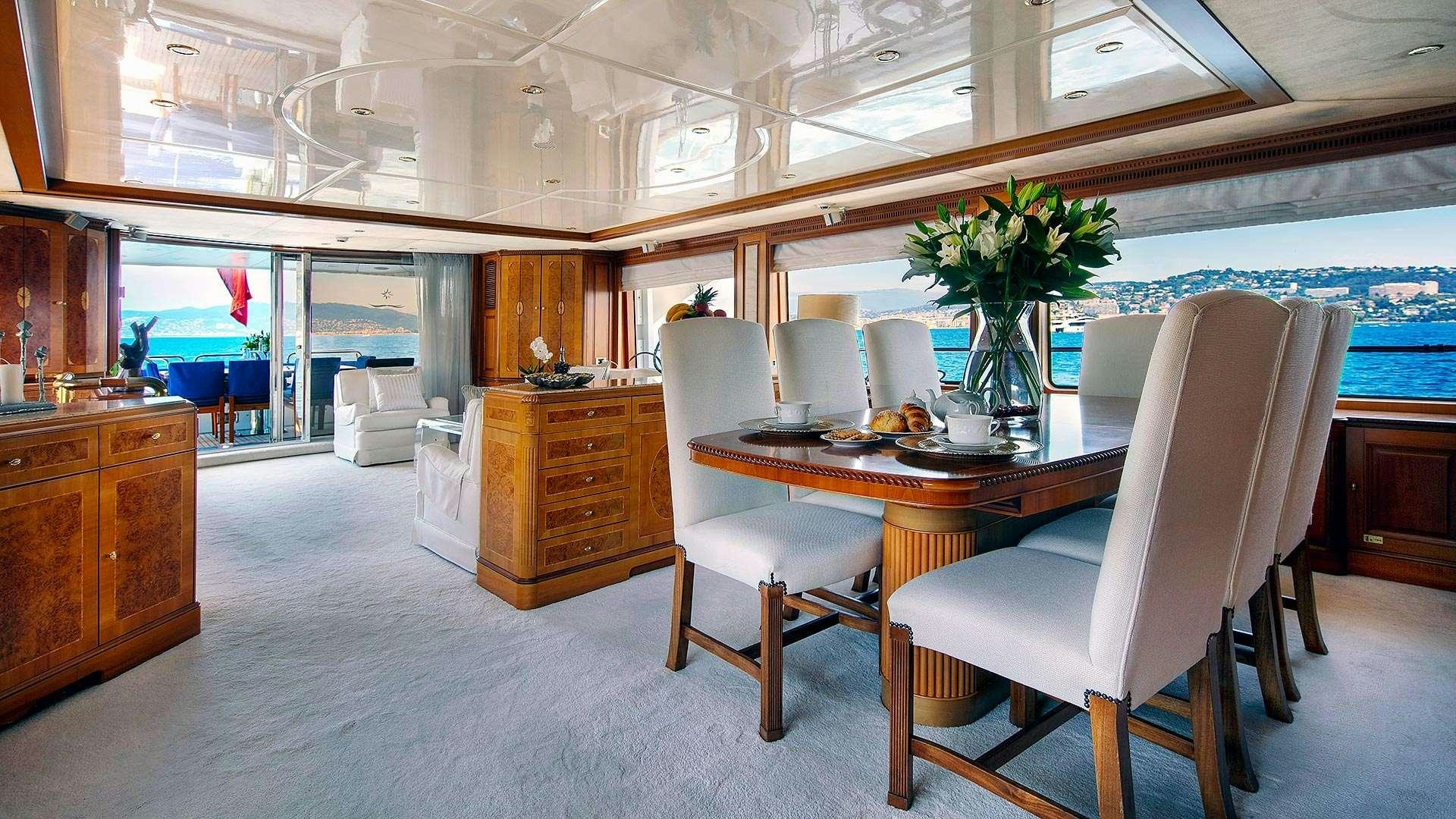 a room with a table chairs and a plant in a vase aboard NEW STAR Yacht for Charter
