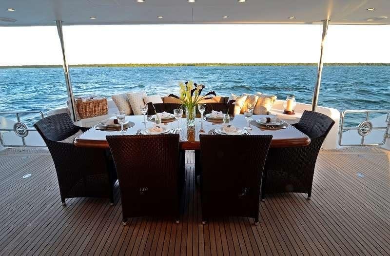 a table set for a meal on a deck overlooking the ocean aboard BLUE HORIZON Yacht for Charter