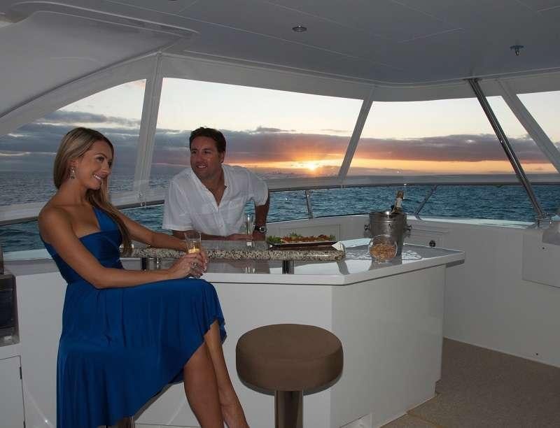 a man and woman sitting at a table with a glass of wine aboard BLUE HORIZON Yacht for Charter