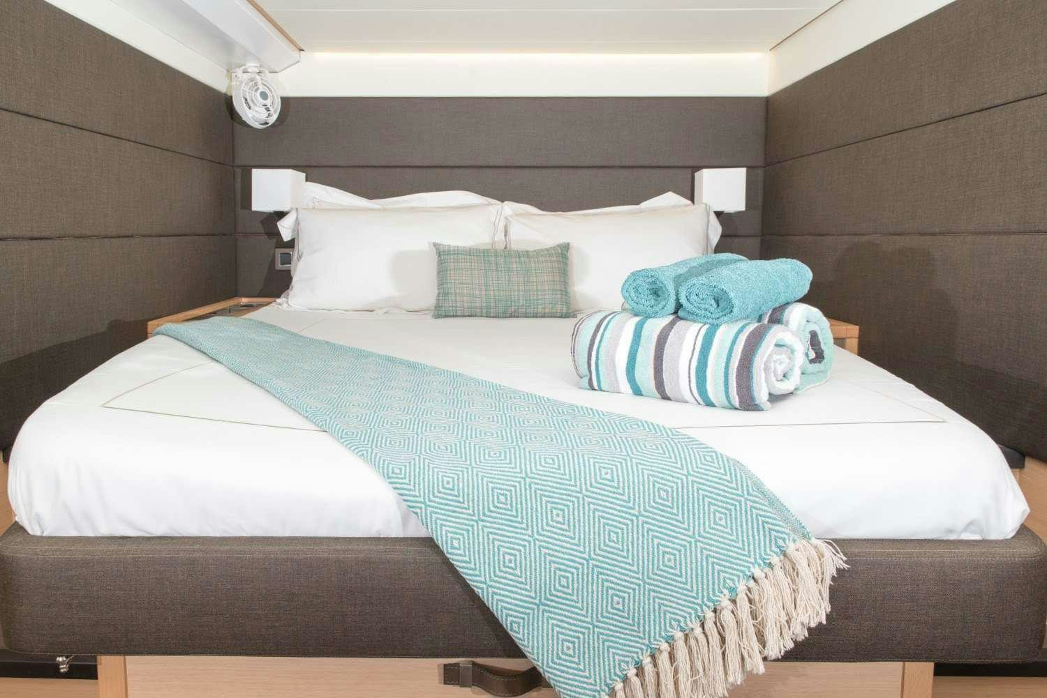 a bed with blue and white sheets aboard MELARNIE Yacht for Charter