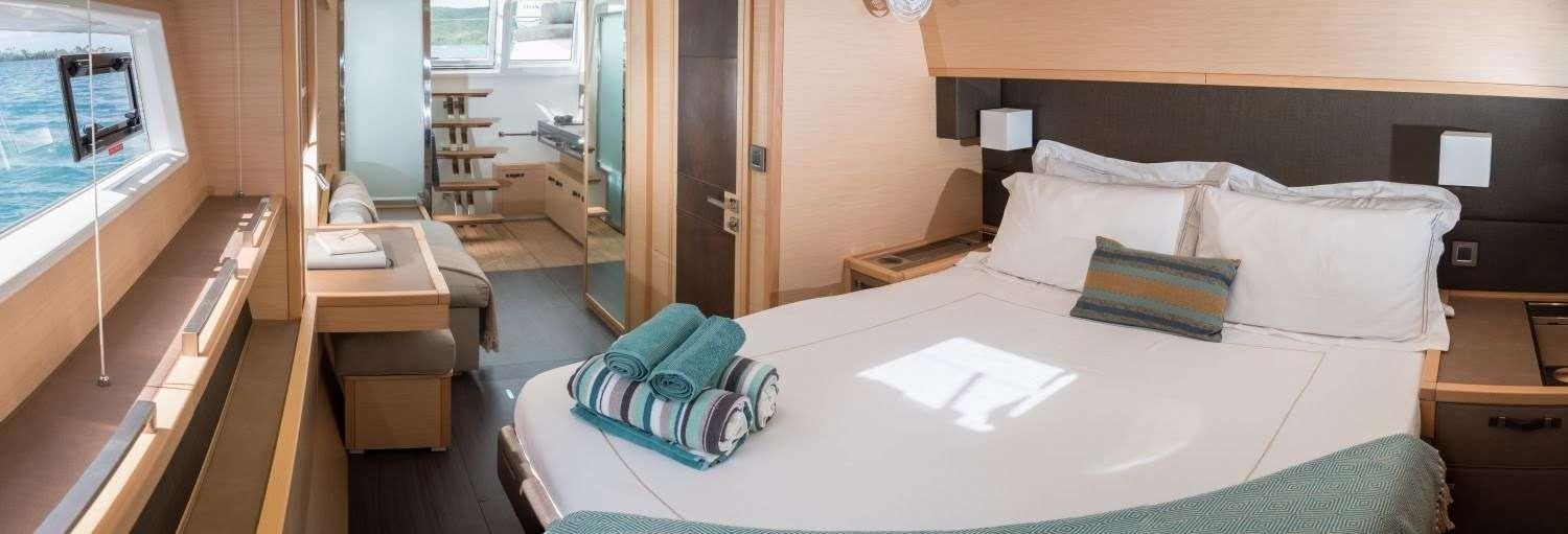 a bed with white sheets and pillows aboard MELARNIE Yacht for Charter