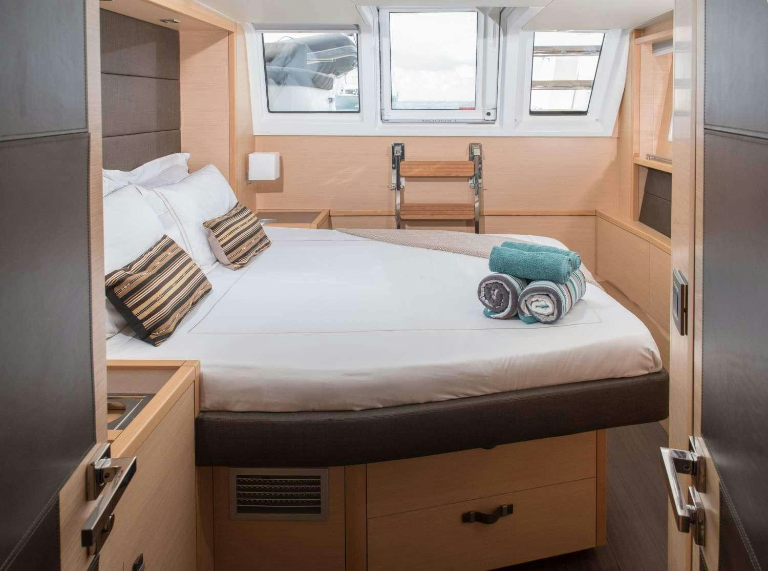 a bed with a white sheet and pillows on it aboard MELARNIE Yacht for Charter