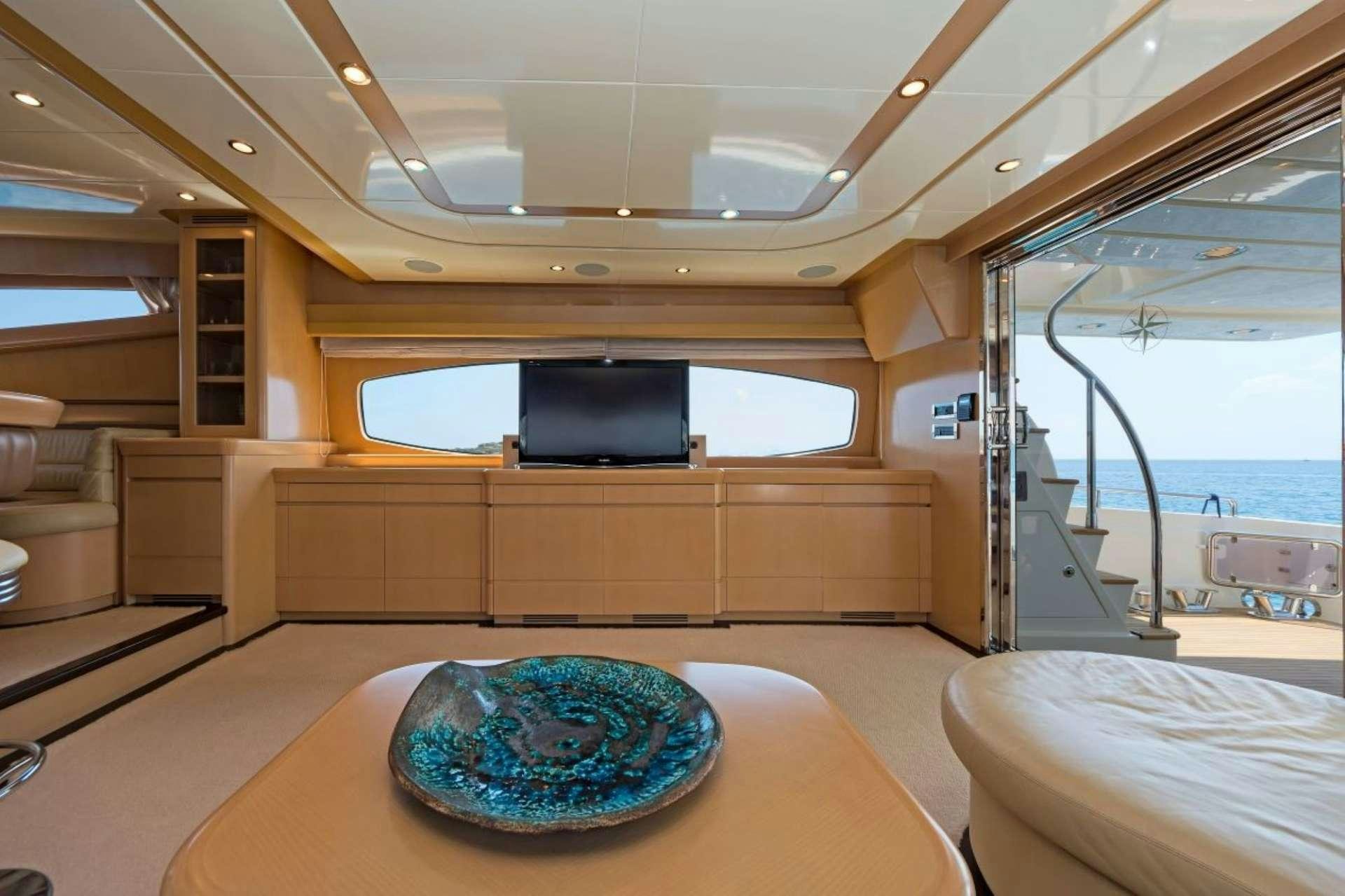 a room with a large window and a table with a blue plate on it aboard LETTOULI III Yacht for Charter
