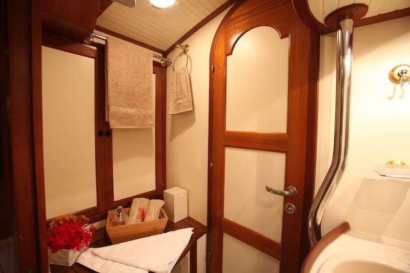 a bathroom with a wood door aboard MORGANE Yacht for Charter