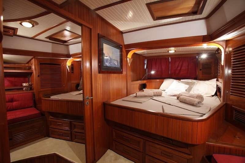 a room with a bed and a television aboard MORGANE Yacht for Charter