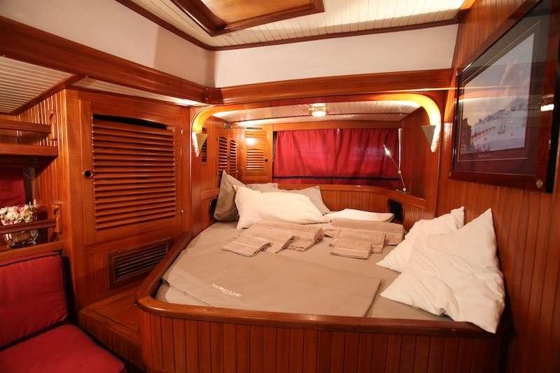 a bed with a white sheet aboard MORGANE Yacht for Charter