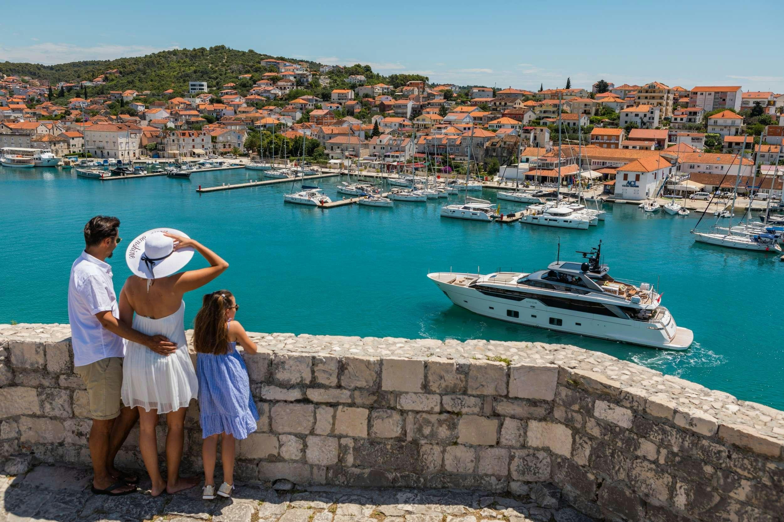 a group of people looking at boats in the water aboard NOOR II Yacht for Charter