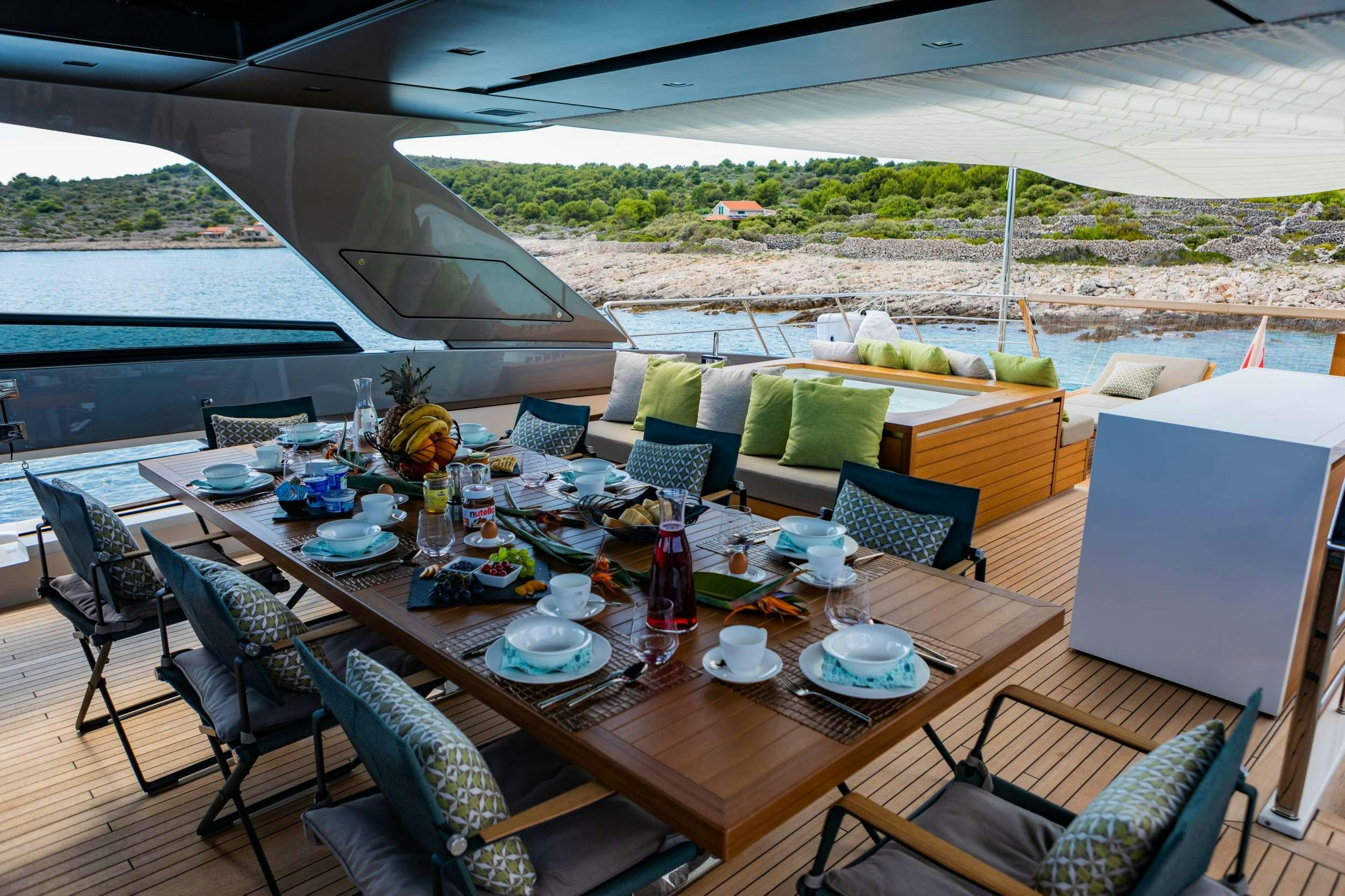 a table set for a meal on a deck aboard NOOR II Yacht for Charter