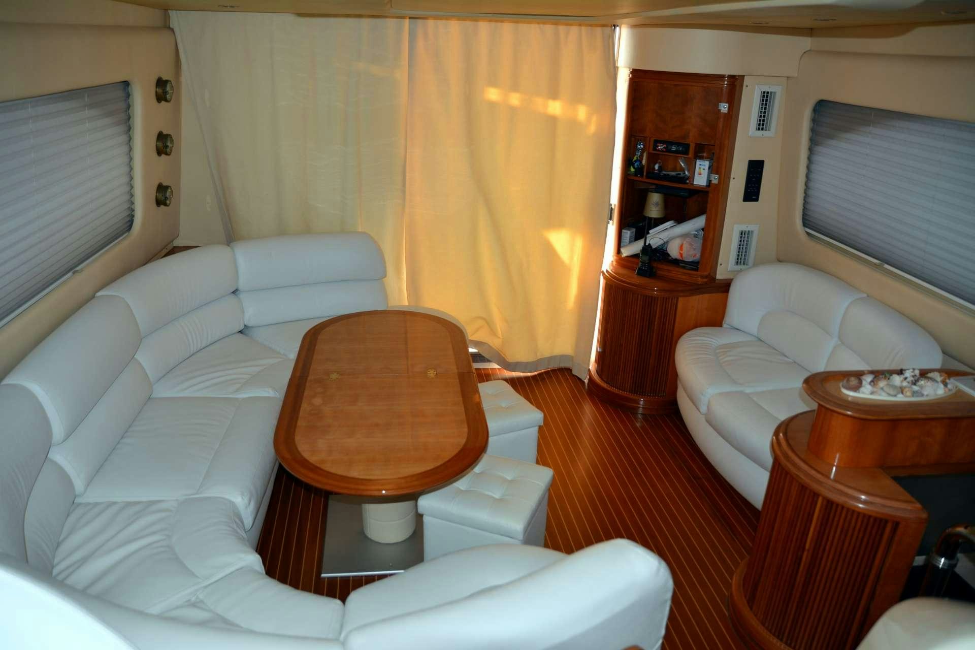 a living room with white couches aboard ALMA LIBRE II Yacht for Charter