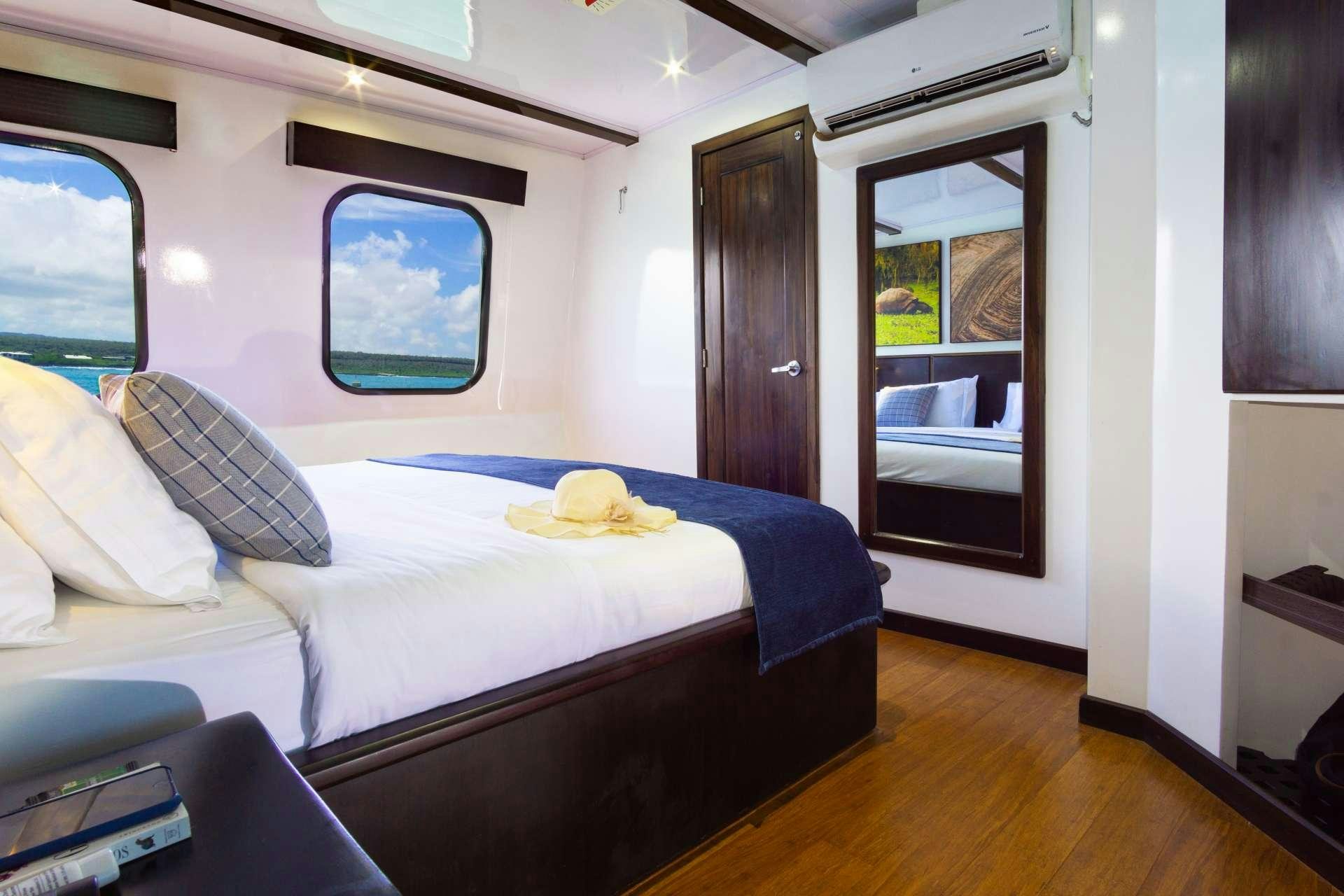 a bedroom with a bed and a window aboard NATURAL PARADISE Yacht for Charter