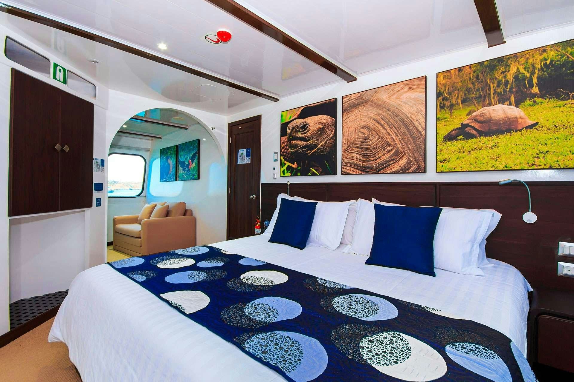 a bed with blue and white sheets aboard NATURAL PARADISE Yacht for Charter