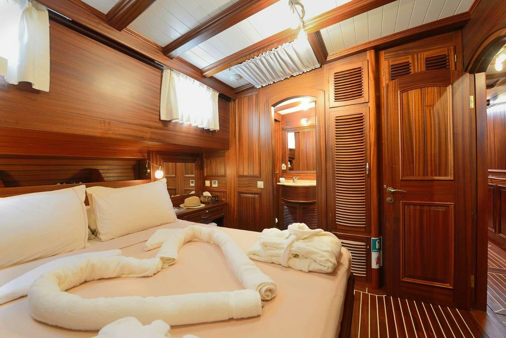 a room with a bed and a wood door aboard ZEPHYRIA II Yacht for Charter