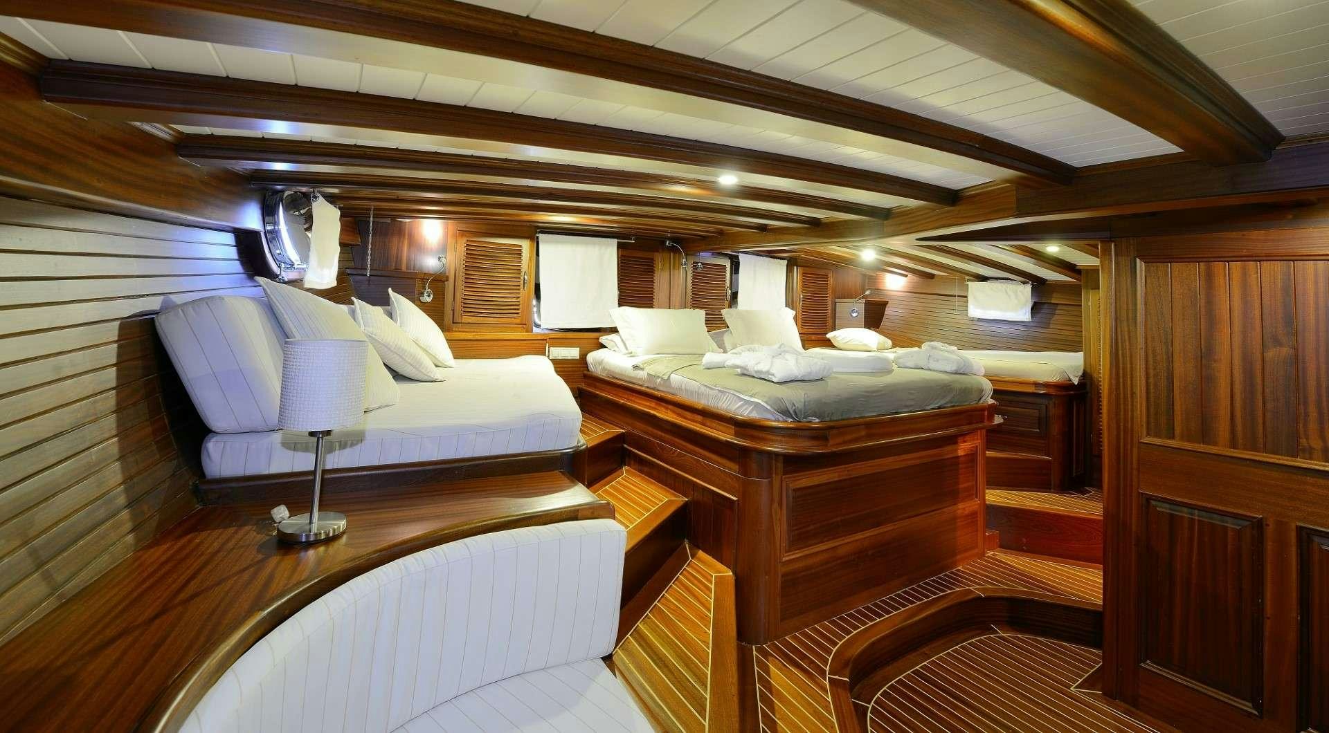 a room with a bed and a table aboard ZEPHYRIA II Yacht for Charter