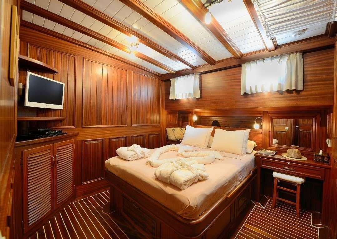 a room with a bed and a tv aboard ZEPHYRIA II Yacht for Charter