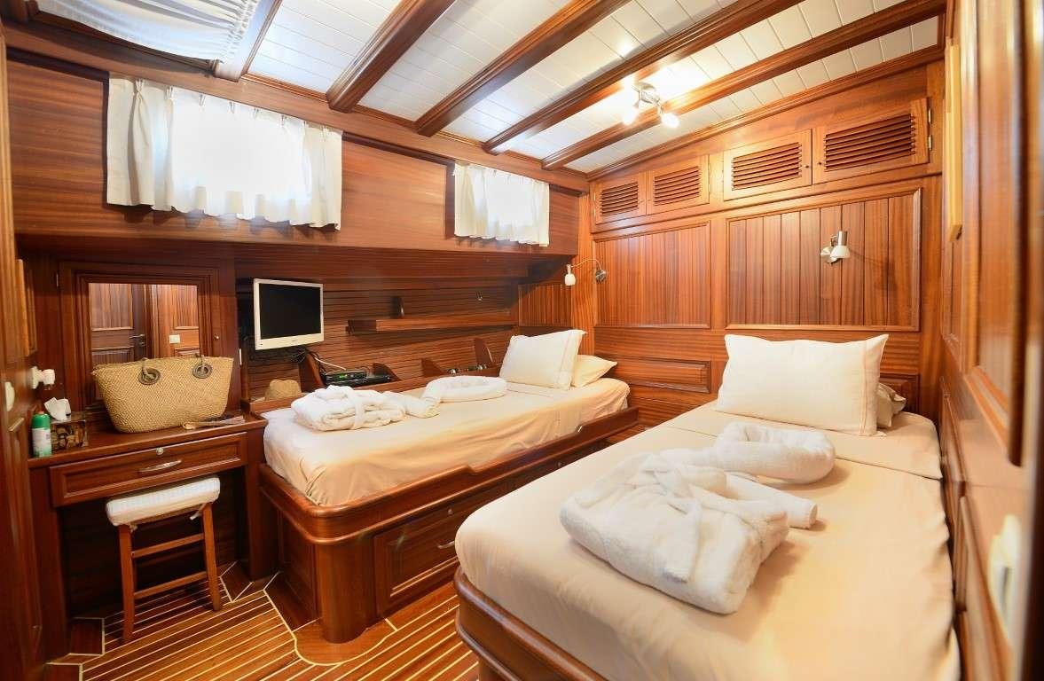 a room with a bed and a desk aboard ZEPHYRIA II Yacht for Charter