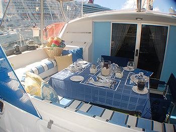 a table with a cloth and chairs on it aboard CATALYST Yacht for Charter