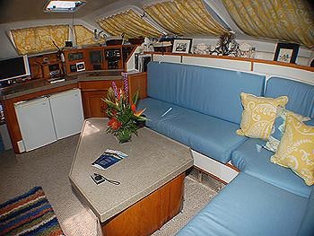 a living room with a blue couch aboard CATALYST Yacht for Charter