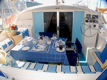 a table with chairs and a fan aboard CATALYST Yacht for Charter