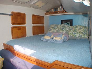 a bedroom with a bed and a chair aboard CATALYST Yacht for Charter