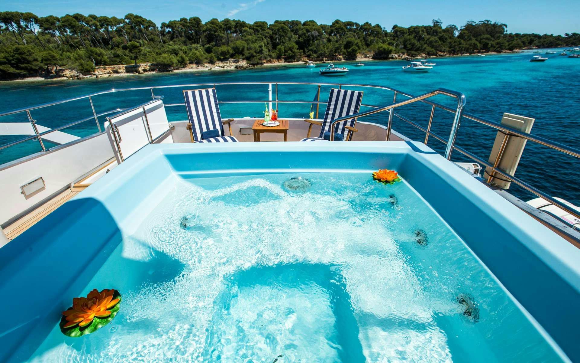 a swimming pool with chairs and a table and chairs on the deck aboard STAR OF THE SEA Yacht for Charter