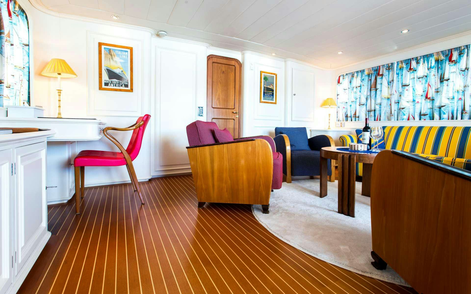 a large room with a table and chairs aboard STAR OF THE SEA Yacht for Charter