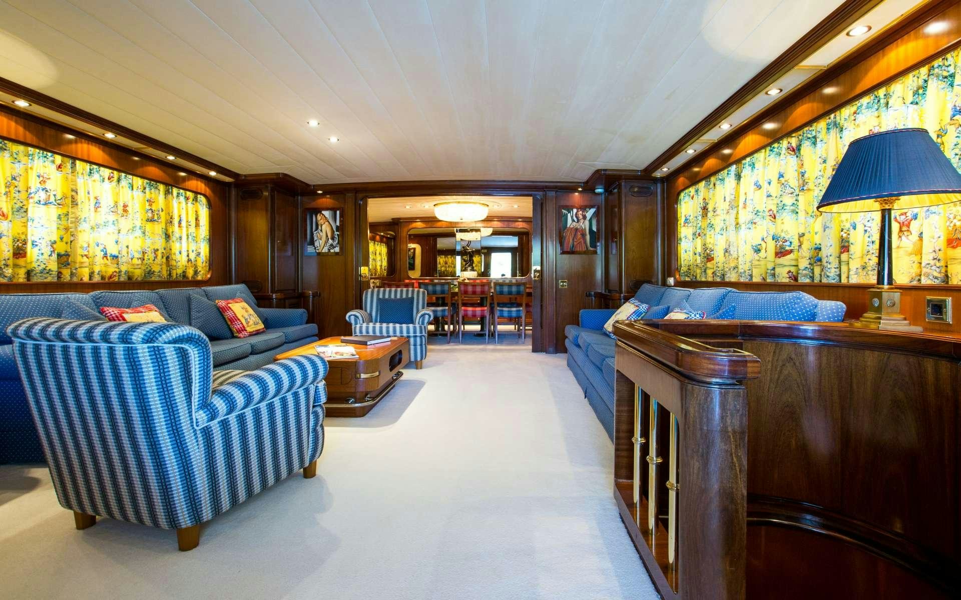 a living room with a blue couch aboard STAR OF THE SEA Yacht for Charter