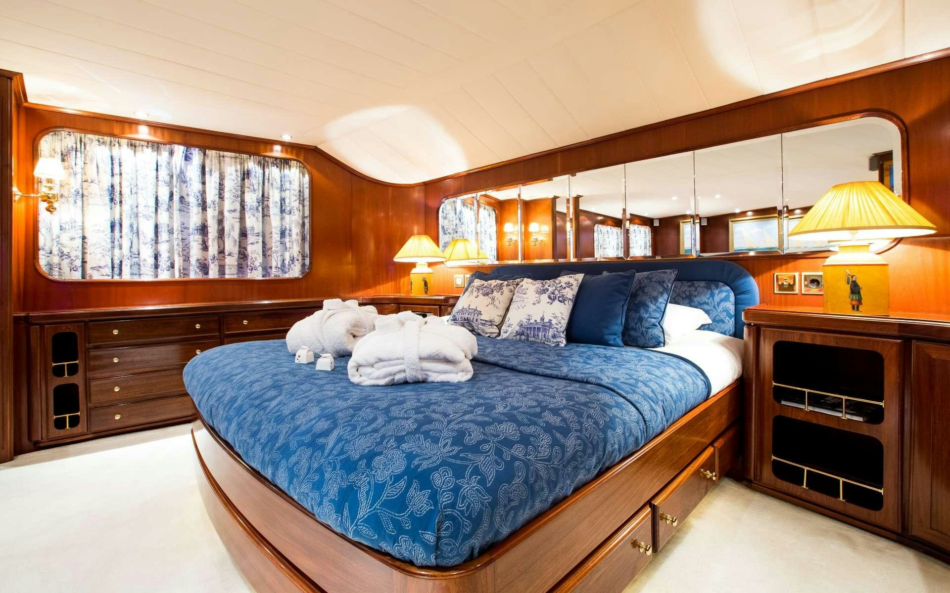 a bed with a blue comforter aboard STAR OF THE SEA Yacht for Charter