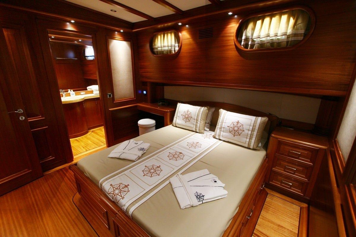 a room with a bed and a desk aboard KAYA GUNERI V Yacht for Charter