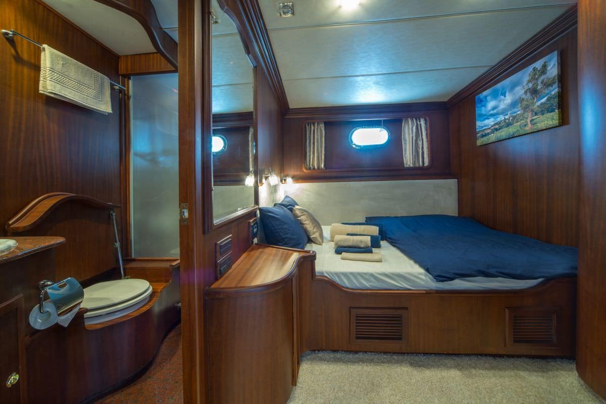a bedroom with a bed and desk aboard ALBA Yacht for Charter