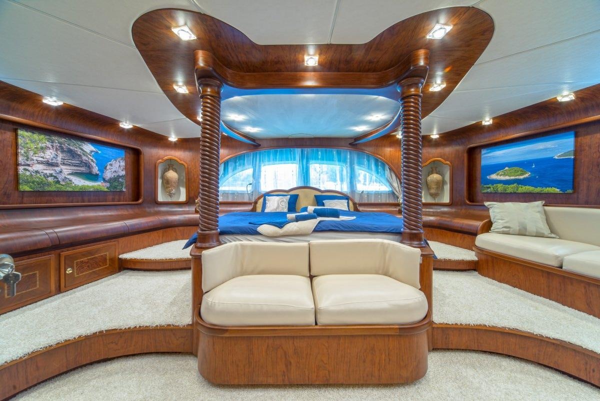 a room with a bed and a couch aboard ALBA Yacht for Charter